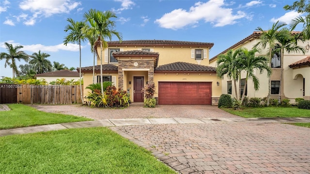 mediterranean / spanish home with a garage and a front lawn