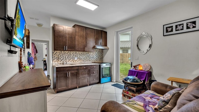 kitchen featuring backsplash, stainless steel range with electric stovetop, dark brown cabinetry, and sink