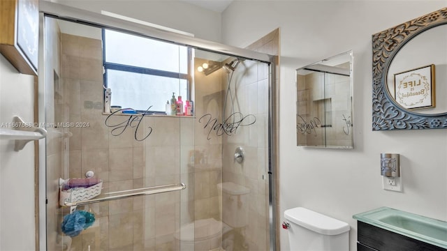 bathroom featuring vanity, toilet, and an enclosed shower