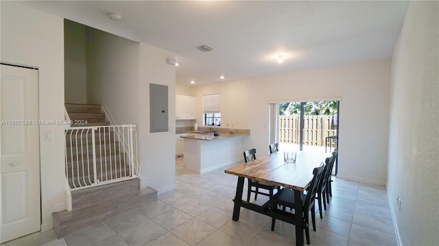 dining space featuring electric panel and light tile patterned flooring