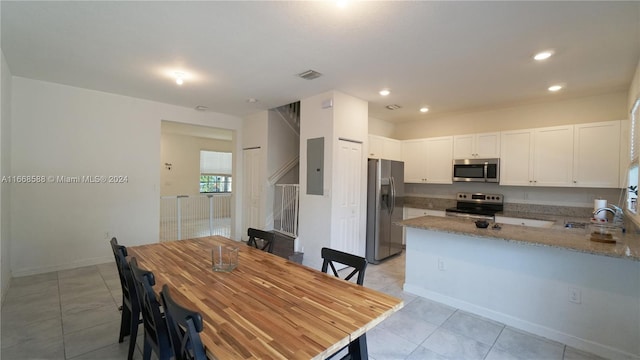 dining space featuring electric panel, light tile patterned floors, and sink