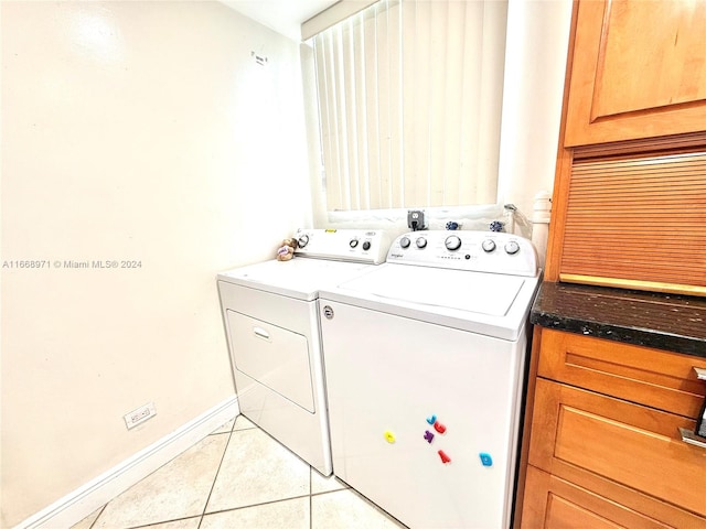 laundry area with washing machine and clothes dryer and light tile patterned floors