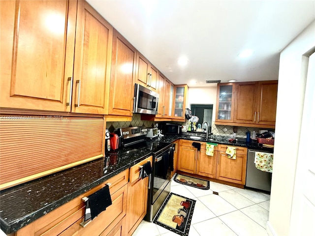 kitchen featuring backsplash, light tile patterned flooring, sink, and stainless steel appliances