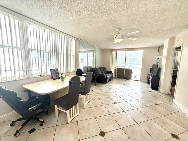 dining area with ceiling fan, light tile patterned floors, and a textured ceiling