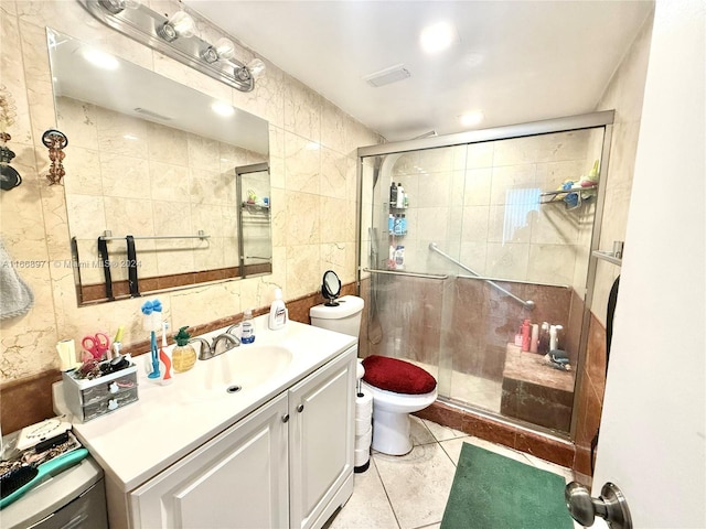 bathroom featuring tile walls, tile patterned flooring, a shower with door, vanity, and toilet