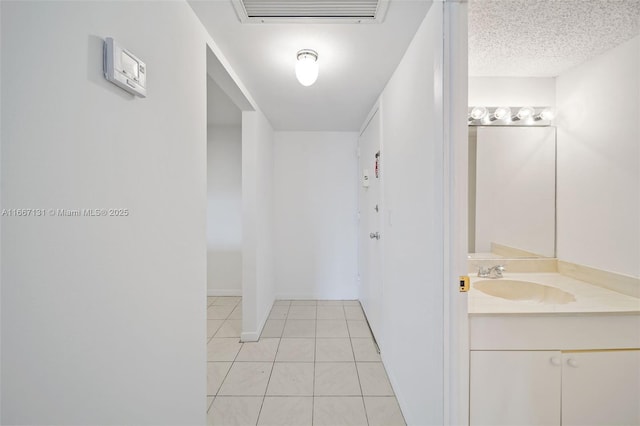 bathroom featuring tile patterned flooring, vanity, and a textured ceiling