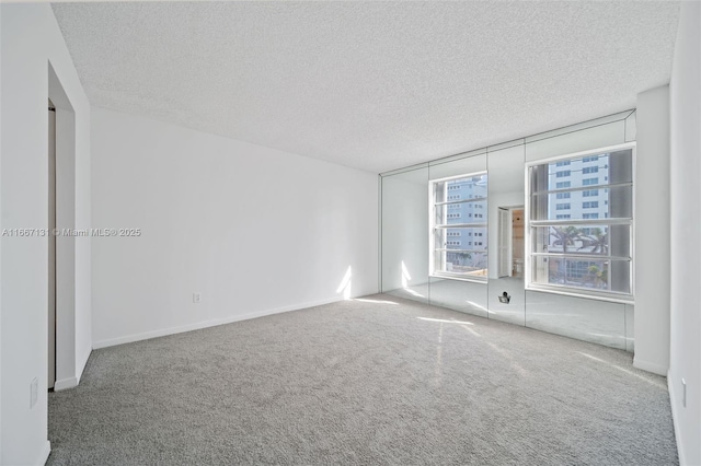 unfurnished room with a textured ceiling and carpet floors