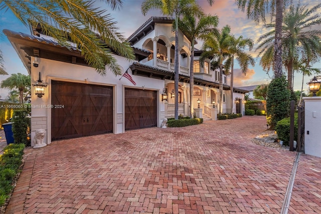 mediterranean / spanish house with a balcony and a garage