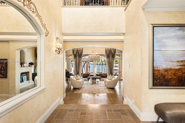 entrance foyer featuring a notable chandelier, a high ceiling, and crown molding