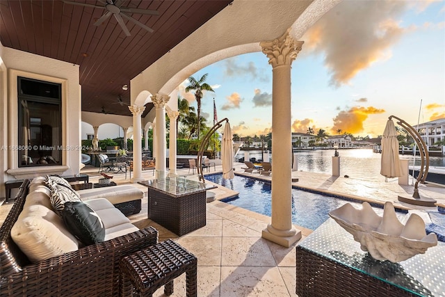 patio terrace at dusk with ceiling fan and a water view