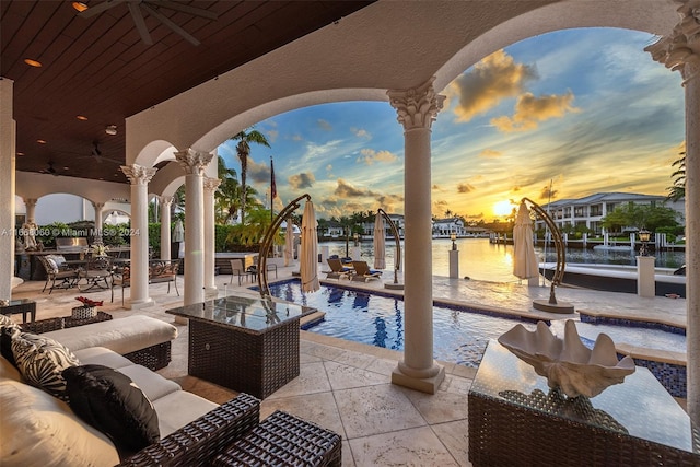 patio terrace at dusk with a water view and ceiling fan