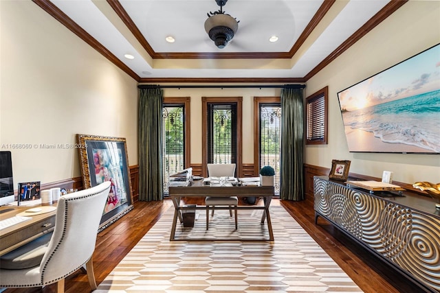 office with ornamental molding, wood-type flooring, and a raised ceiling