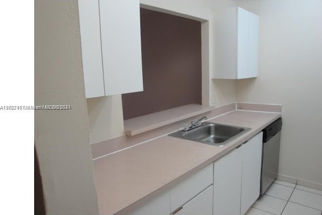 kitchen featuring stainless steel dishwasher, light tile patterned flooring, sink, and white cabinets