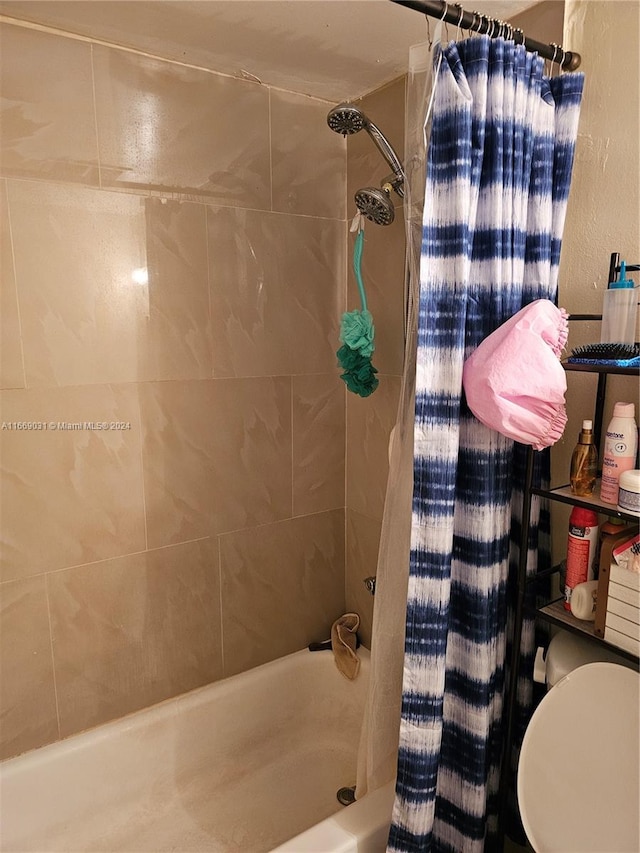 bathroom featuring shower / bath combo with shower curtain and toilet