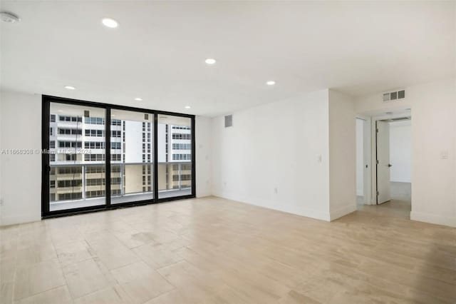 unfurnished room with expansive windows