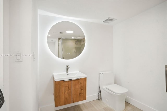 bathroom featuring a shower, vanity, and toilet