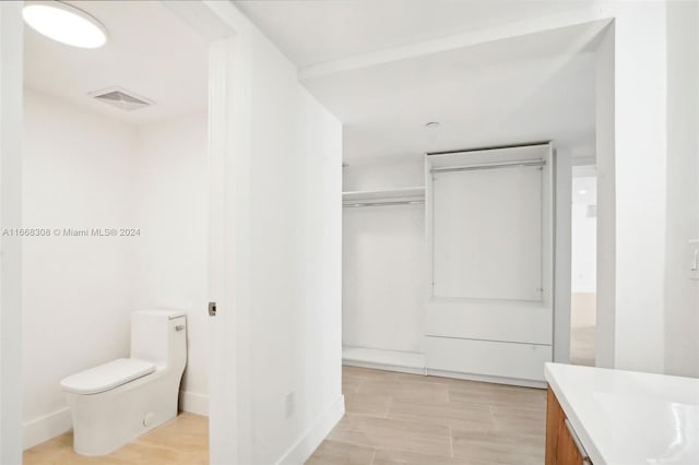 bathroom featuring hardwood / wood-style floors, vanity, and toilet