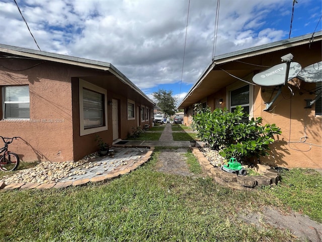view of home's exterior with stucco siding and a yard