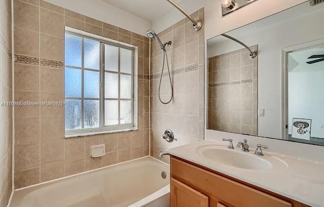 bathroom featuring tiled shower / bath combo and vanity