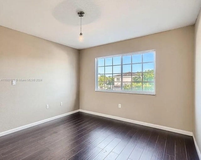 unfurnished room with dark hardwood / wood-style flooring