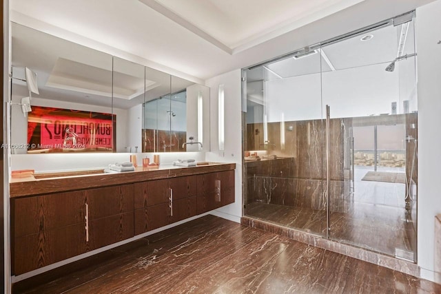 bathroom with a tray ceiling, hardwood / wood-style floors, vanity, and an enclosed shower