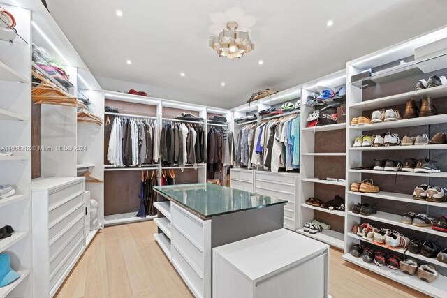450 Alton Rd Unit Ph2, Miami Beach, FL 33139 - walk in closet featuring light wood-type flooring and a chandelier