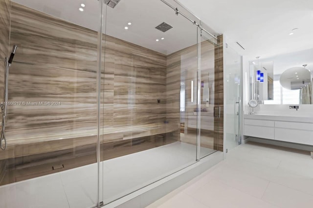 bathroom featuring a shower with door, vanity, and tile patterned floors