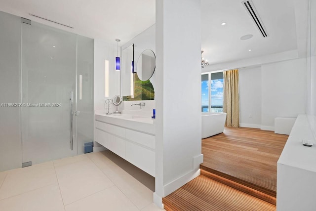 bathroom with shower with separate bathtub, vanity, and tile patterned floors