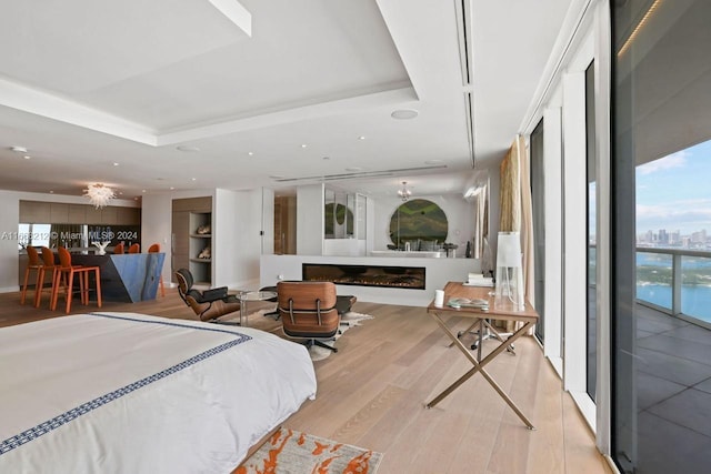 450 Alton Rd Unit Ph2, Miami Beach, FL 33139 - bedroom with wood finished floors, a tray ceiling, a glass covered fireplace, access to exterior, and recessed lighting