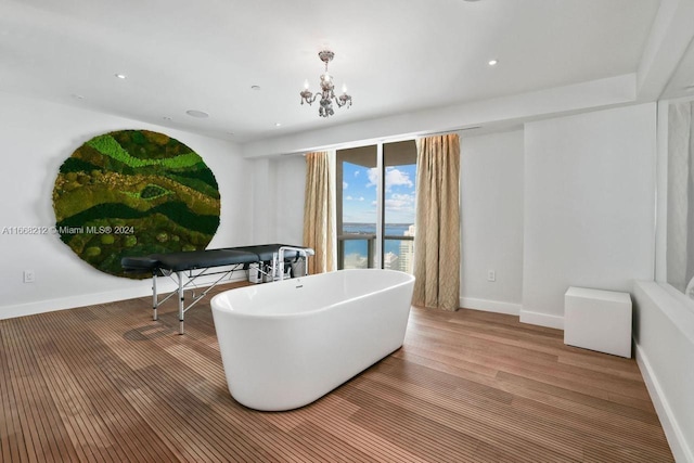 bathroom with a water view, a bath, and hardwood / wood-style flooring