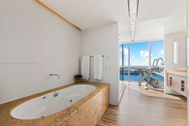 450 Alton Rd Unit Ph2, Miami Beach, FL 33139 - bathroom with a water view, a jetted tub, wood finished floors, and a wall of windows