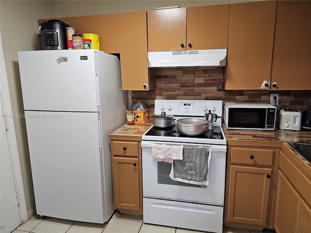 kitchen featuring decorative backsplash, white appliances, and light tile patterned floors