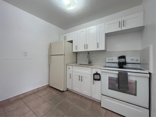 kitchen with white appliances, light countertops, white cabinetry, a sink, and backsplash