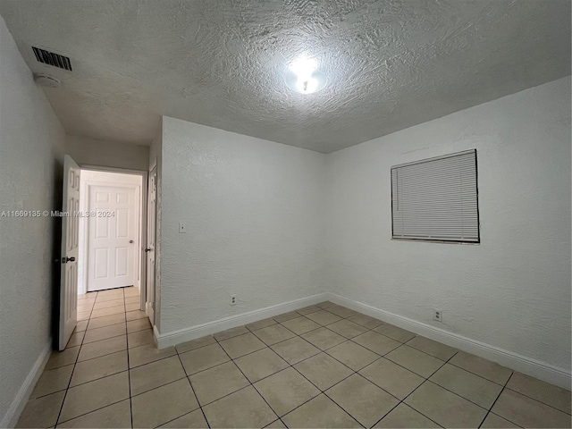 spare room featuring baseboards and light tile patterned floors