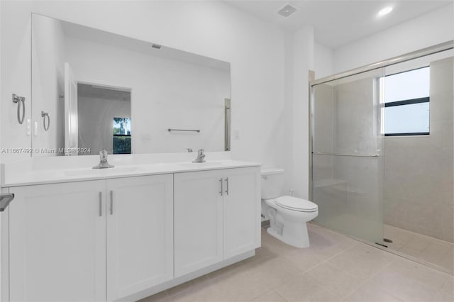 bathroom featuring plenty of natural light, tile patterned flooring, a shower with door, and toilet