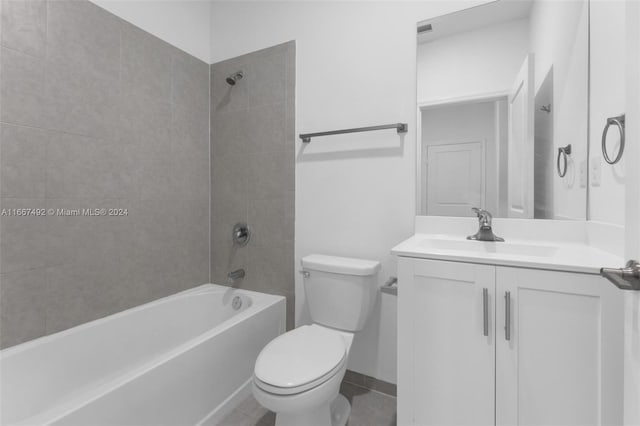 full bathroom featuring tile patterned floors, vanity, tiled shower / bath, and toilet