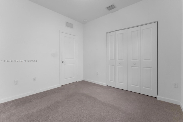 unfurnished bedroom featuring carpet flooring and a closet