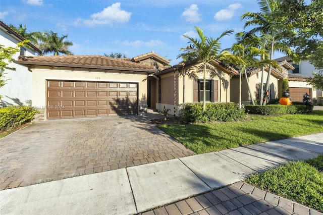 mediterranean / spanish-style home featuring a front lawn and a garage