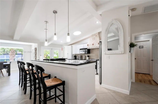 kitchen with a kitchen bar, white cabinetry, light tile patterned floors, kitchen peninsula, and pendant lighting