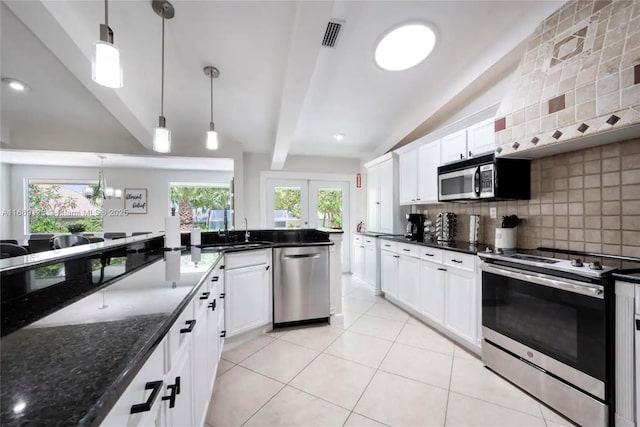 kitchen with hanging light fixtures, appliances with stainless steel finishes, and white cabinets