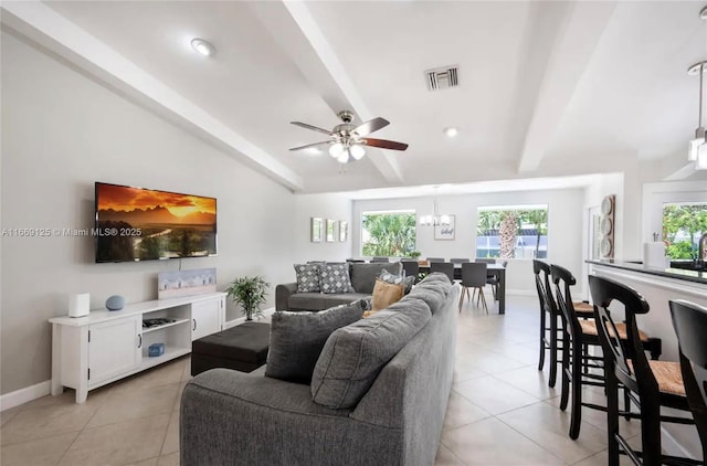 tiled living room with lofted ceiling with beams and ceiling fan with notable chandelier