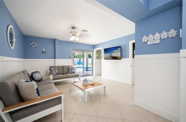 tiled living room with ceiling fan and french doors