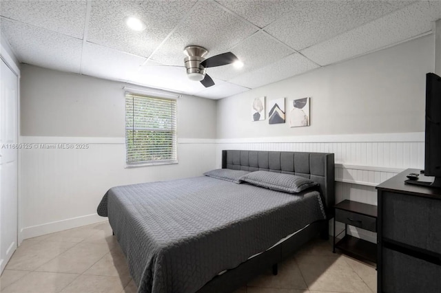 tiled bedroom with a paneled ceiling and ceiling fan