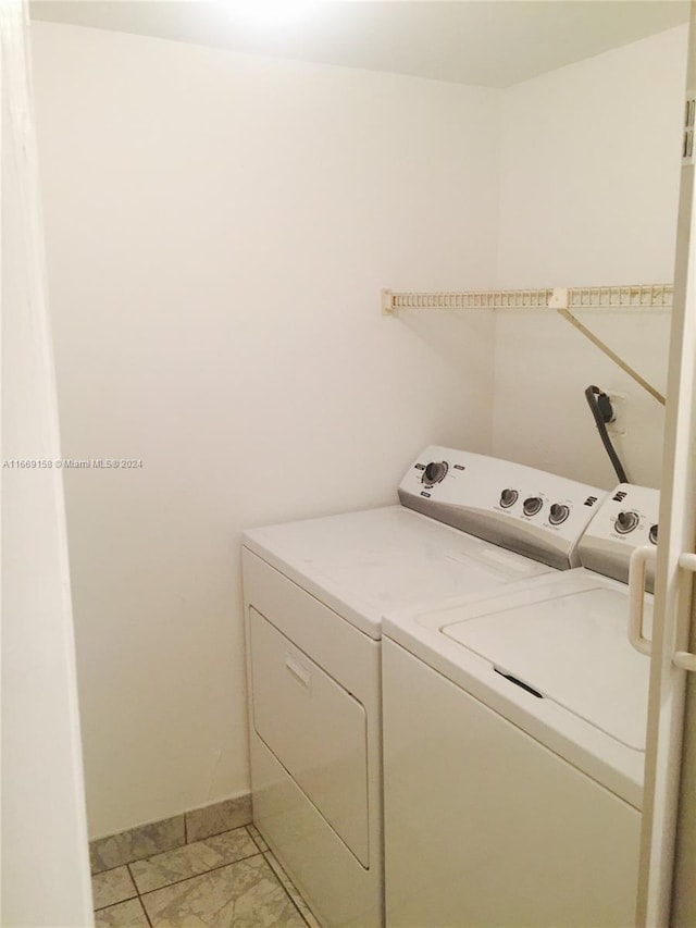 clothes washing area with separate washer and dryer and light tile patterned floors