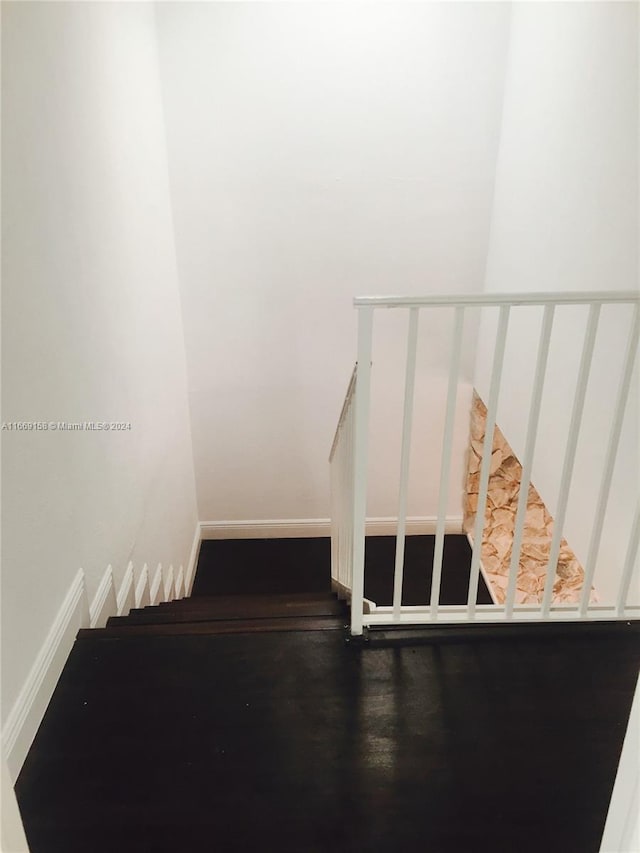 staircase with hardwood / wood-style floors