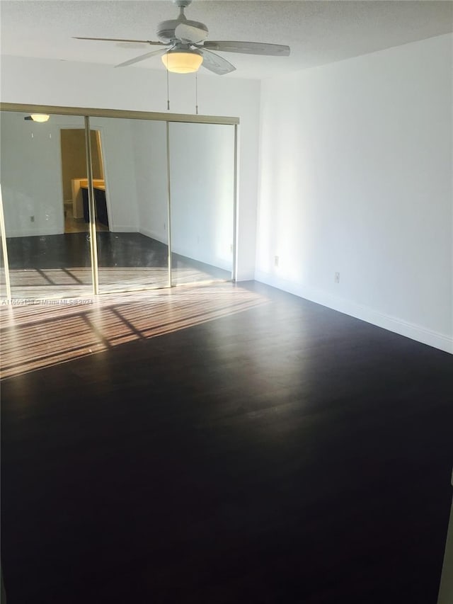 unfurnished bedroom featuring a textured ceiling, hardwood / wood-style floors, ceiling fan, and a closet