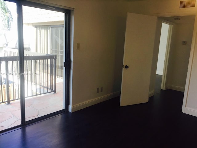 spare room featuring plenty of natural light and dark hardwood / wood-style floors