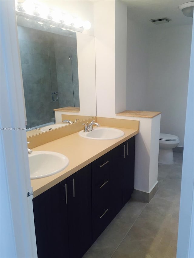 bathroom with a shower with shower door, vanity, and toilet