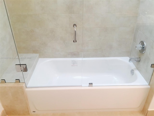 bathroom featuring tiled shower / bath combo and tile patterned flooring