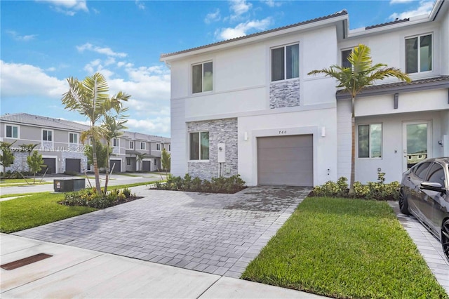 view of front facade featuring a garage, central AC unit, and a front lawn